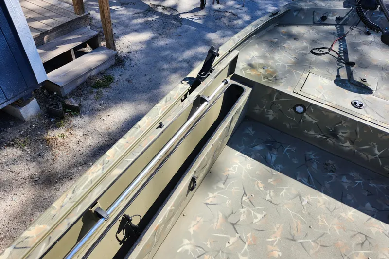 Slide: The Image of 2025 Tracker Grizzly 1654 MVX Sportsman boat interior with camouflage design and storage compartments. - 22