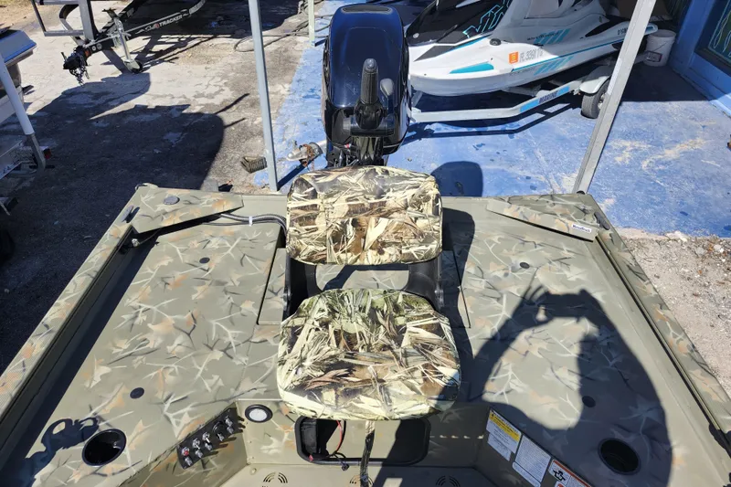 Slide: The Image of 2025 Tracker Grizzly 1654 MVX Sportsman boat with camouflage seats and motor. - 27