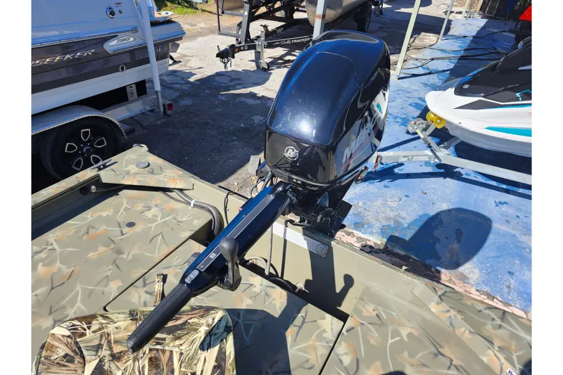 Slide: The Image of 2025 Tracker Grizzly 1654 MVX Sportsman boat with camo design and outboard motor. - 29