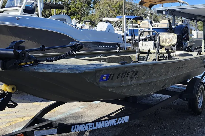 Slide: The Image of 2025 Tracker Grizzly 1654 MVX Sportsman boat on trailer at marina. - 3