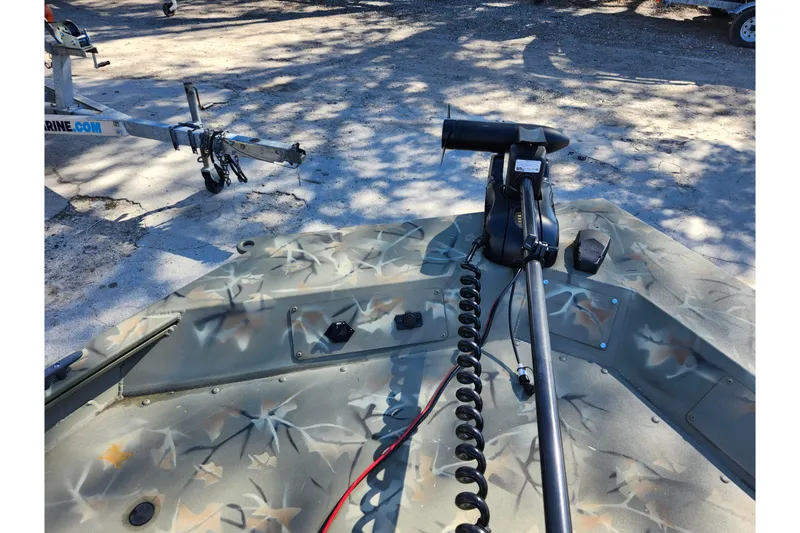 Slide: The Image of 2025 Tracker Grizzly 1654 MVX Sportsman boat with camouflage design and trolling motor. - 36