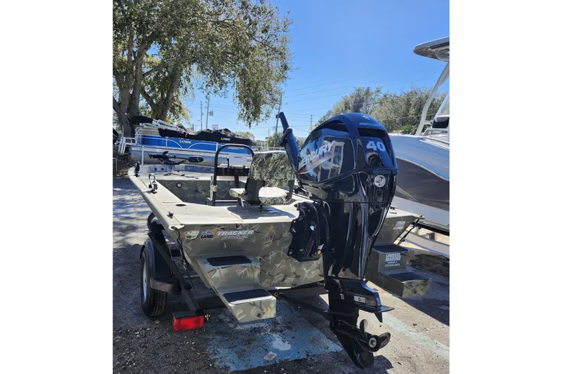 Slide: The Image of 2025 Tracker Grizzly 1654 MVX Sportsman boat with Mercury 40 engine, parked outdoors. - 5