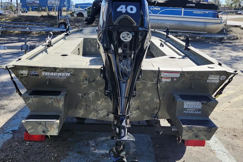 Slide: The Image of 2025 Tracker Grizzly 1654 MVX Sportsman boat with camouflage design and outboard motor. - 7