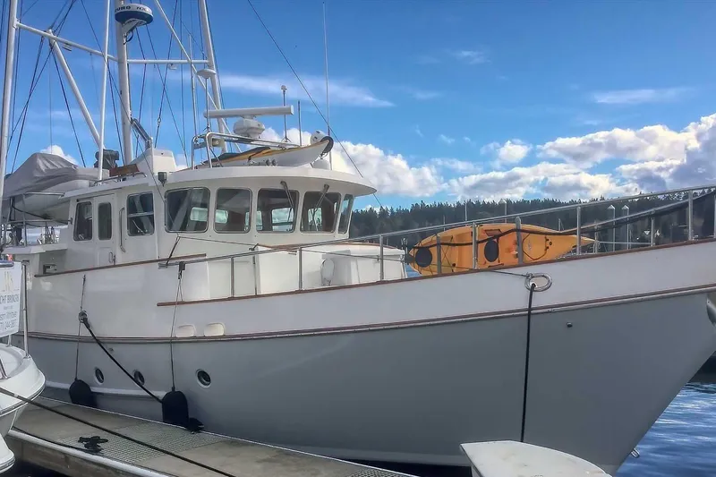 Slide: The Image of 2001 Nordhavn 46 yacht docked, featuring a sleek design and vibrant blue sky backdrop. - 0