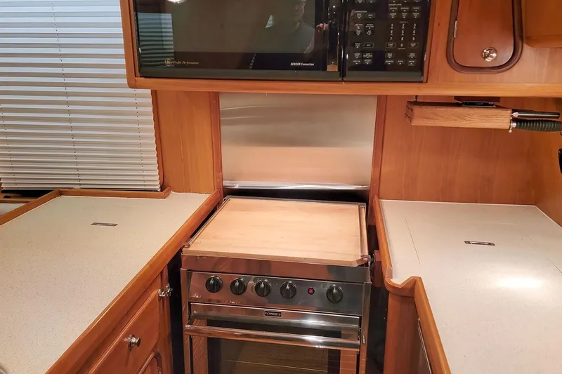 Slide: The Image of 2001 Nordhavn 46 yacht kitchen with stove, microwave, and wooden cabinetry. - 18