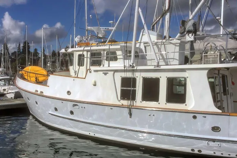Slide: The Image of 2001 Nordhavn 46 yacht docked at marina under blue sky. - 2