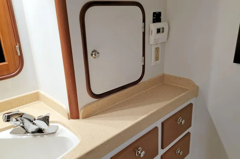 Slide: The Image of 2001 Nordhavn 46 yacht bathroom with sink, storage cabinets, and control panel. - 24