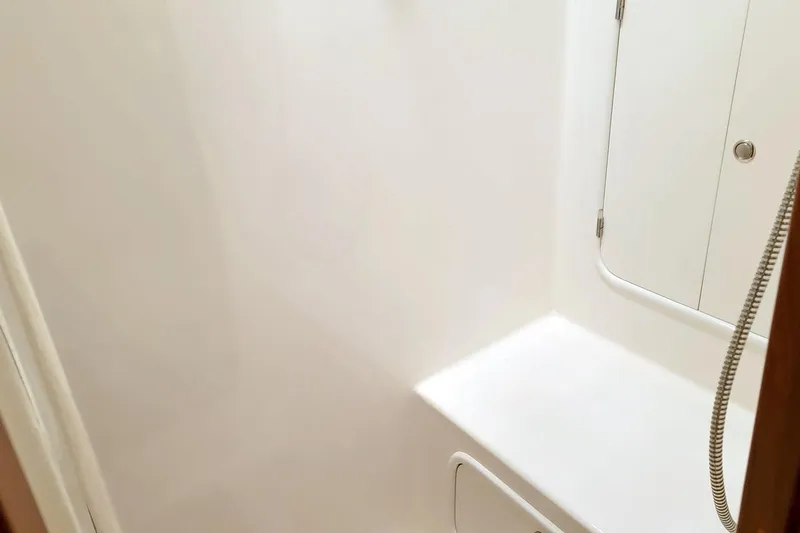 Slide: The Image of Interior of 2001 Nordhavn 46 yacht, featuring a clean, white shower area. - 25