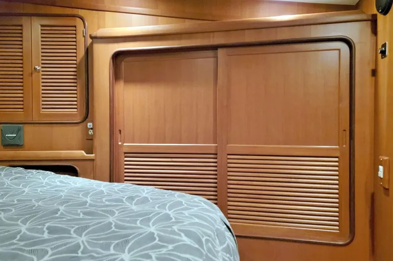 Slide: The Image of Interior of 2001 Nordhavn 46 yacht with wooden cabinetry and patterned bedding. - 29