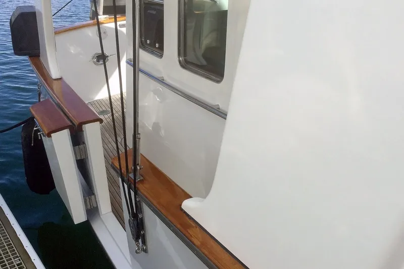 Slide: The Image of 2001 Nordhavn 46 yacht deck with wooden railings and ocean view. - 3