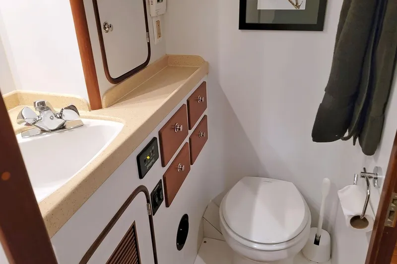 Slide: The Image of Compact bathroom in 2001 Nordhavn 46 yacht with sink, toilet, and storage cabinets. - 42