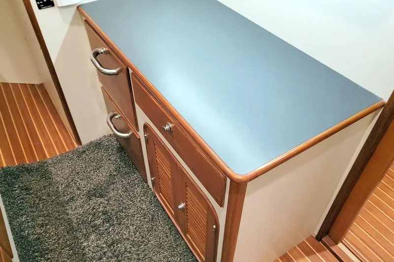 Slide: The Image of 2001 Nordhavn 46 interior with wooden cabinetry and blue countertop. - 48