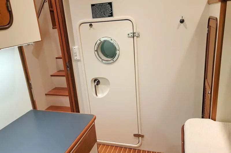 Slide: The Image of Interior of 2001 Nordhavn 46 yacht with porthole door and wooden stairs. - 54
