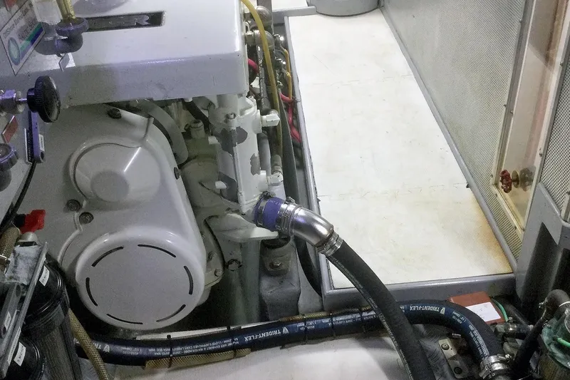 Slide: The Image of Engine room of a 2001 Nordhavn 46 yacht, featuring mechanical components and hoses. - 55