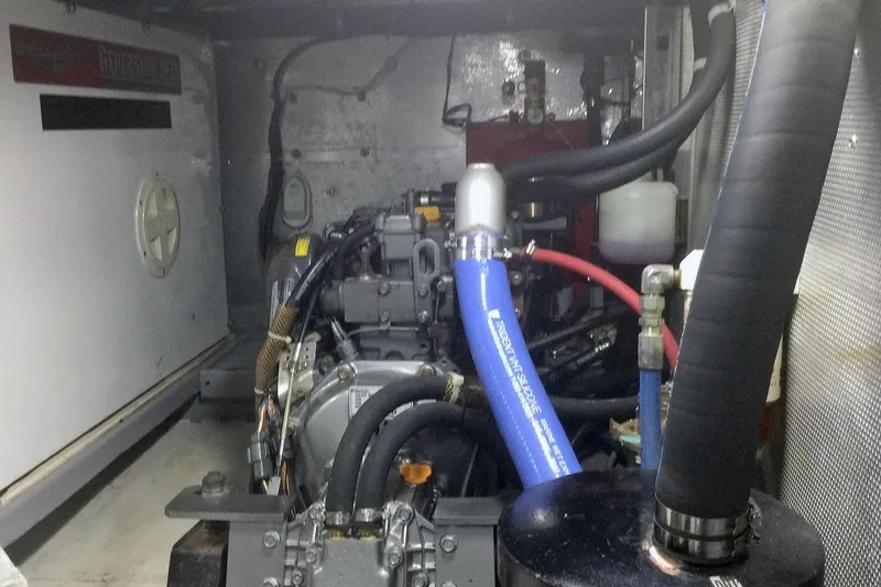 Slide: The Image of Engine room of a 2001 Nordhavn 46 yacht, showcasing mechanical components and hoses. - 58