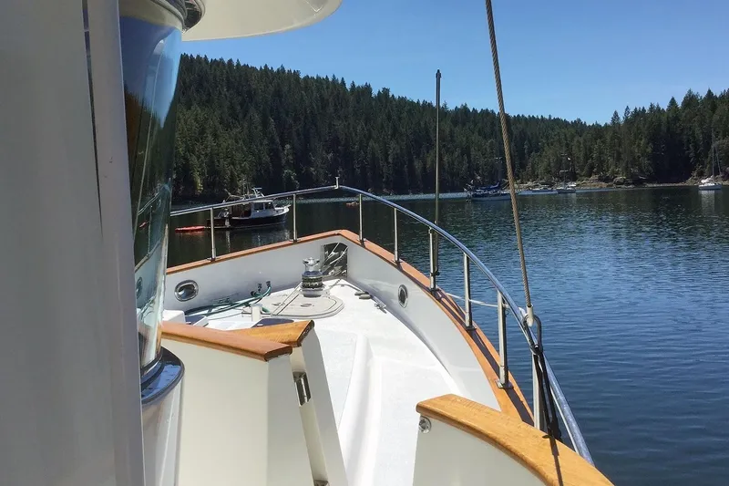Slide: The Image of 2001 Nordhavn 46 yacht on serene lake with forested shoreline. - 6