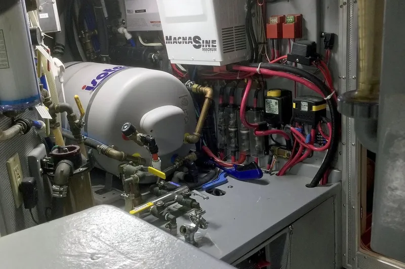 Slide: The Image of Engine room of a 2001 Nordhavn 46 yacht, featuring complex wiring and machinery. - 61