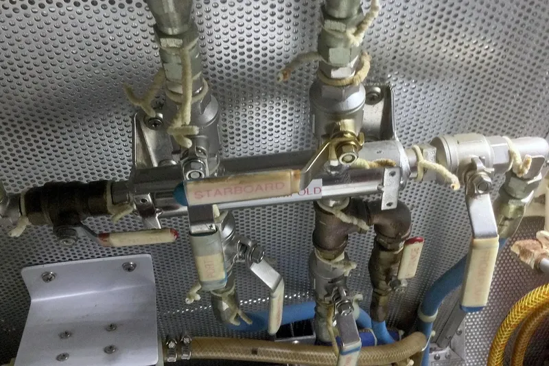 Slide: The Image of Engine room plumbing system of a 2001 Nordhavn 46 yacht, featuring labeled valves and pipes. - 63