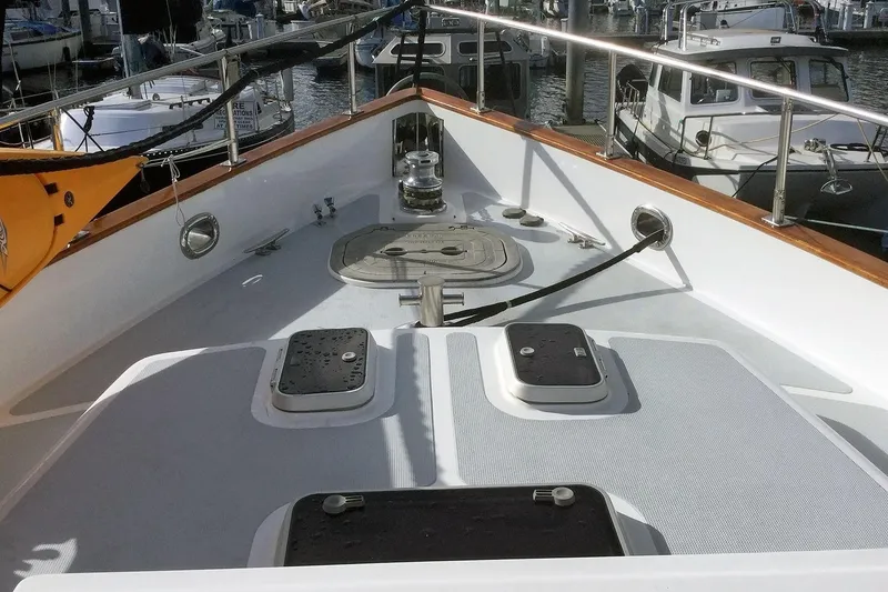 Slide: The Image of Bow deck of 2001 Nordhavn 46 yacht, featuring hatches and winch, docked at marina. - 7