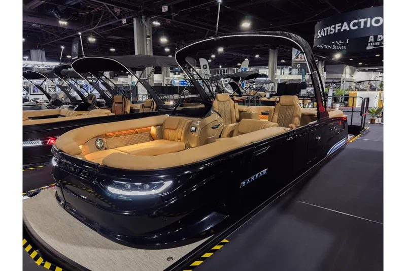 The Image of 2026 Godfrey SanPan 25' Split Bench Co-Captain pontoon boat at indoor exhibition. - 0