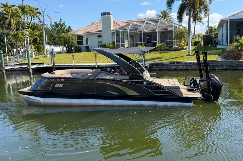 The Image of 2024 Bennington 25 QX Swingback pontoon boat on a sunny waterfront. - 0
