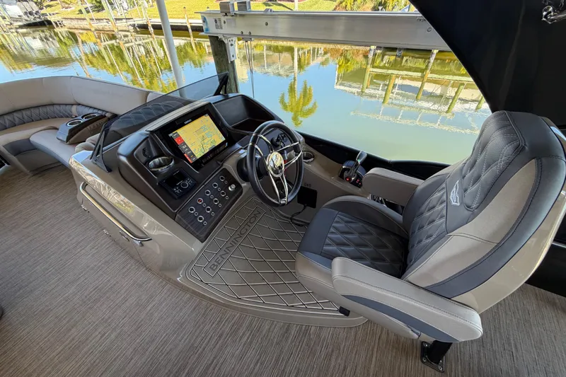 Slide: The Image of 2024 Bennington 25 QX Swingback boat interior with modern helm and luxurious seating. - 10