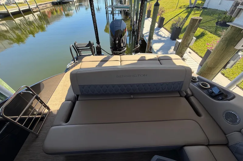 Slide: The Image of 2024 Bennington 25 QX Swingback boat with luxurious seating and modern design by the water. - 15