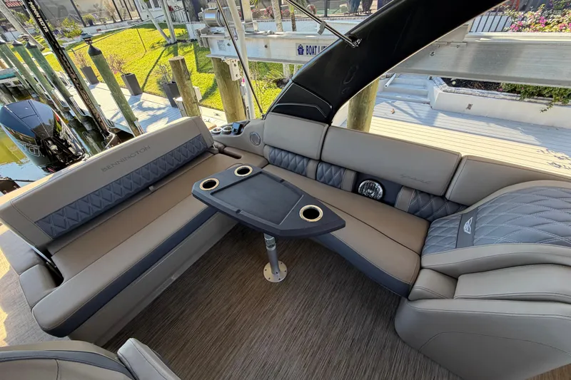 Slide: The Image of Luxurious interior of 2024 Bennington 25 QX Swingback pontoon boat with plush seating and table. - 16