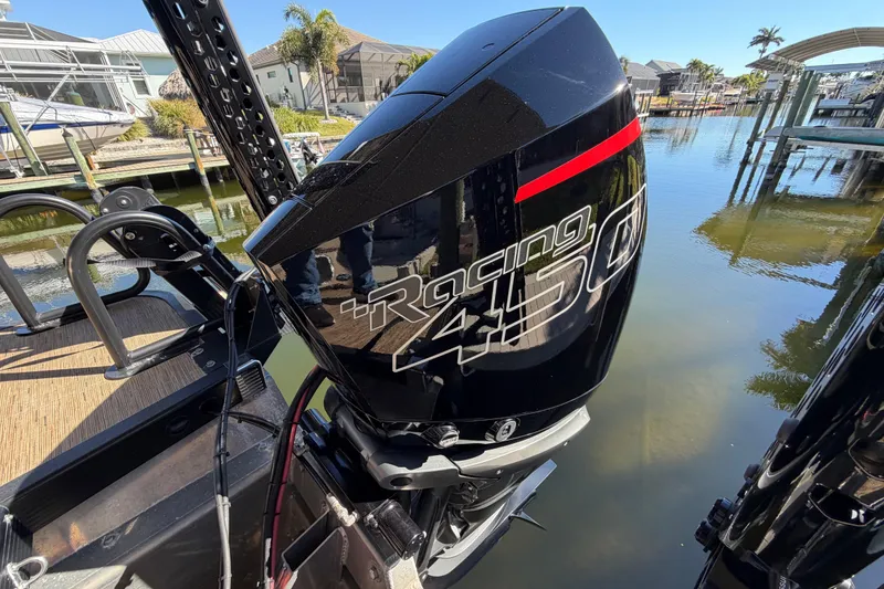 Slide: The Image of 2024 Bennington 25 QX Swingback with powerful Racing 450 engine by the water. - 25