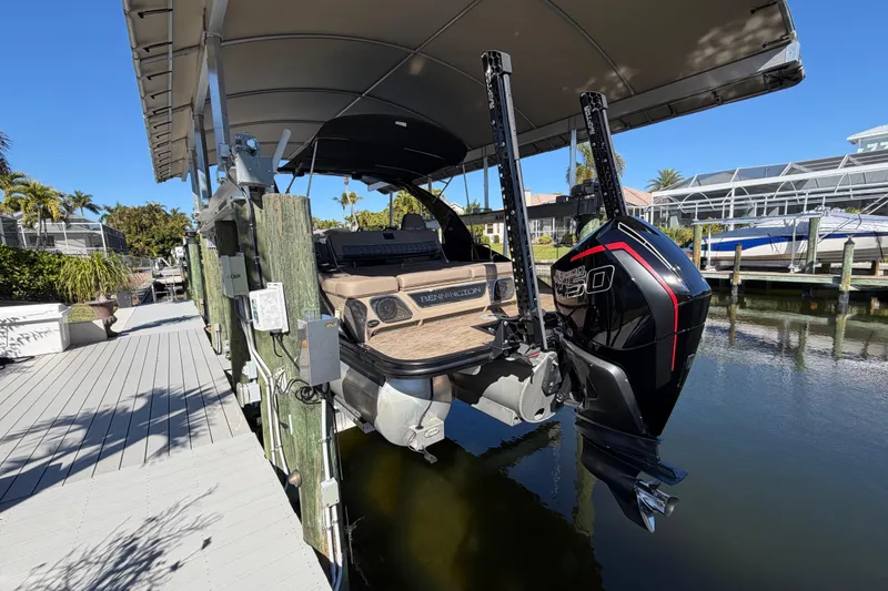 Slide: The Image of 2024 Bennington 25 QX Swingback pontoon boat docked under a canopy. - 31