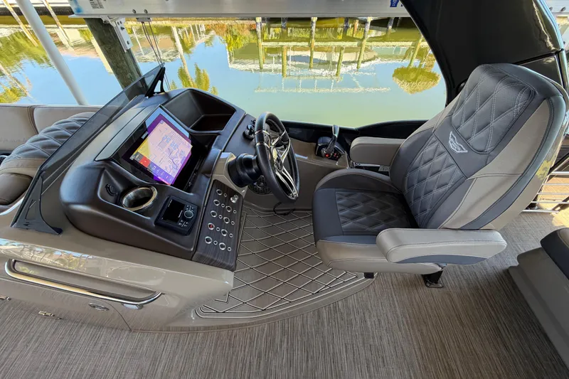Slide: The Image of 2024 Bennington 25 QX Swingback helm with luxurious seating and advanced navigation display. - 9