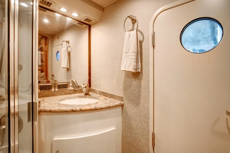 Slide: The Image of Luxurious bathroom in 2007 Viking 68 Convertible yacht with granite countertop and porthole door. - 16