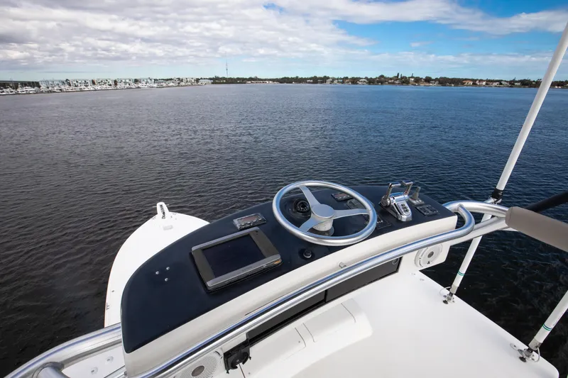 Slide: The Image of Helm of 2007 Viking 68 Convertible yacht overlooking calm waters and distant shoreline. - 23