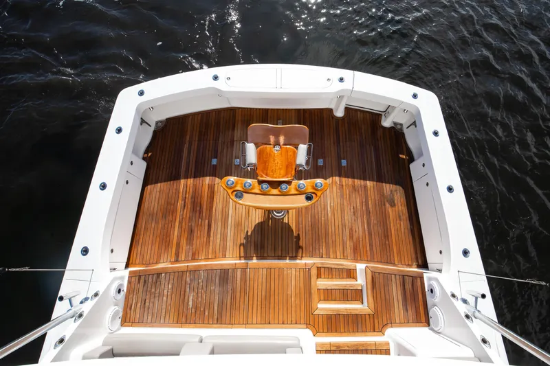 Slide: The Image of 2007 Viking 68 Convertible yacht with teak deck and fishing chair, overlooking water. - 26