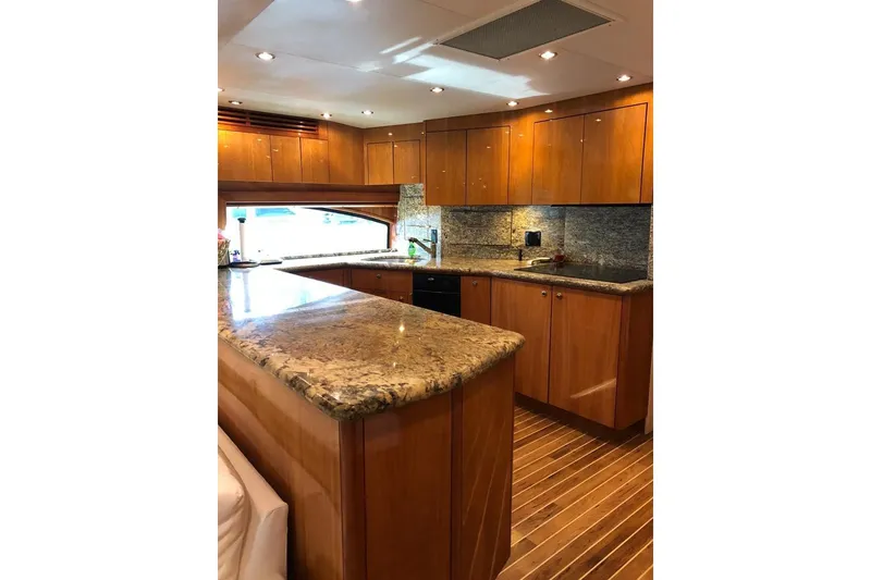 Slide: The Image of Luxurious kitchen interior of 2007 Hatteras 68 Convertible yacht with wooden cabinetry and granite countertops. - 25