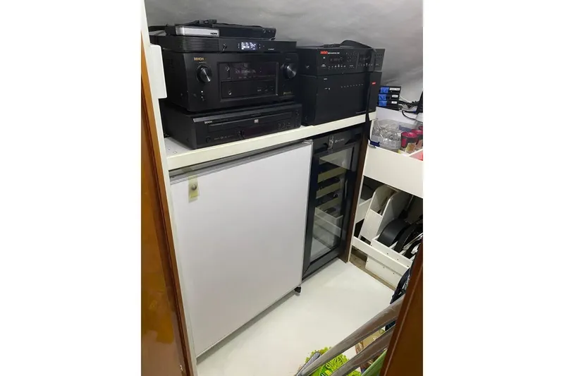 Slide: The Image of Audio equipment and mini fridge setup in 2007 Hatteras 68 Convertible yacht interior. - 26
