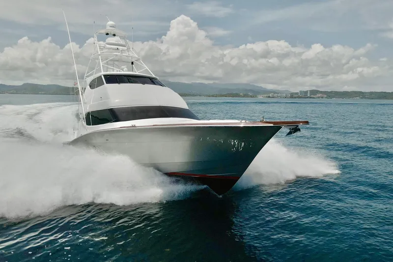 Slide: The Image of 2007 Hatteras 68 Convertible yacht cruising on open water, creating a dynamic wake. - 28