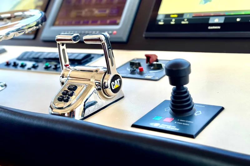 Slide: The Image of Control panel of 2007 Hatteras 68 Convertible yacht with CAT throttle and joystick. - 32