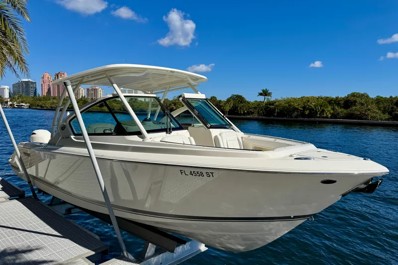 The Image of 2020 Pursuit DC 266 Dual Console boat docked on a sunny day, cityscape in background. - 0
