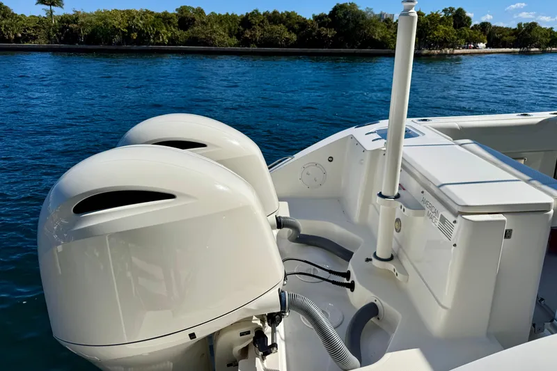 Slide: The Image of 2020 Pursuit DC 266 Dual Console boat with twin outboard engines on a calm blue lake. - 14