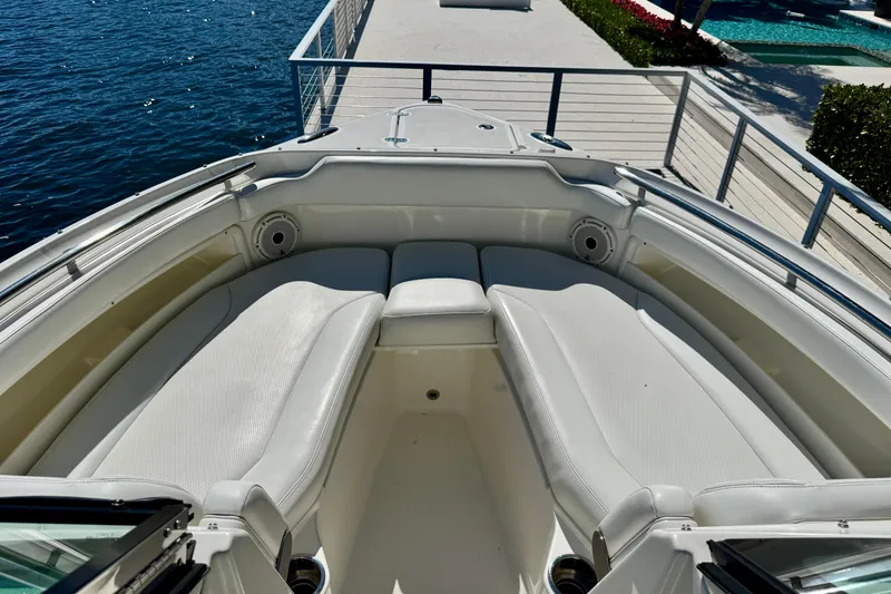 Slide: The Image of 2020 Pursuit DC 266 Dual Console boat with white seating, docked by the water. - 16