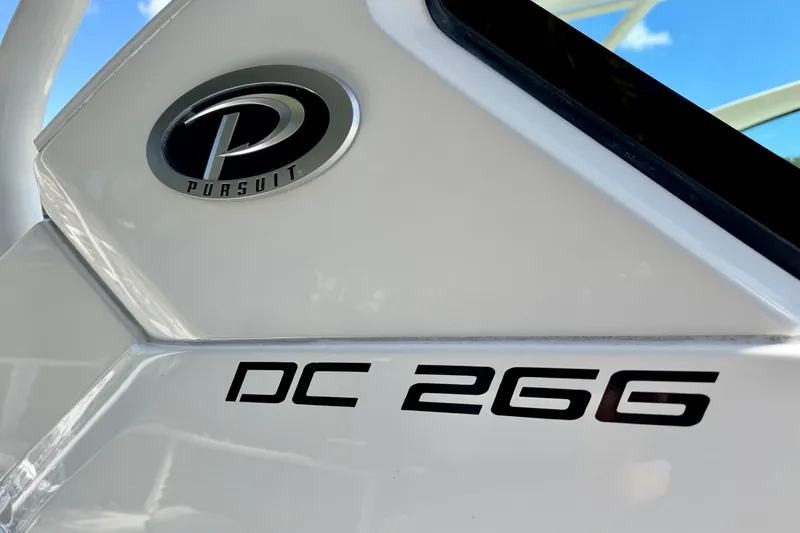 Slide: The Image of 2020 Pursuit DC 266 Dual Console boat logo and model name on white surface. - 23