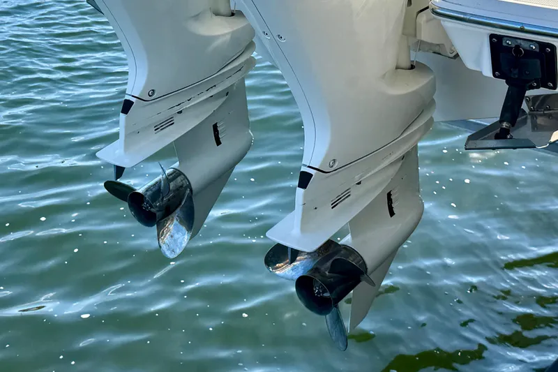 Slide: The Image of 2020 Pursuit DC 266 Dual Console boat engines over water. - 25