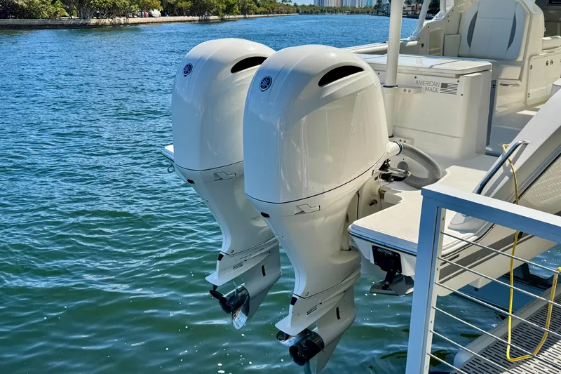 Slide: The Image of 2020 Pursuit DC 266 Dual Console with twin outboard motors on water. - 26