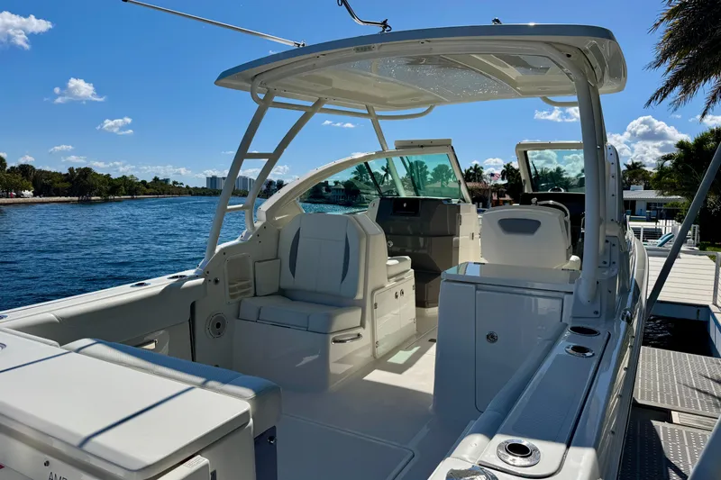 Slide: The Image of 2020 Pursuit DC 266 Dual Console boat docked by a scenic waterfront. - 3