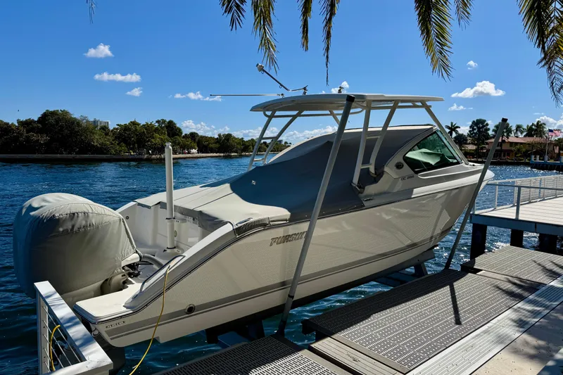 Slide: The Image of 2020 Pursuit DC 266 Dual Console boat docked by a scenic waterfront. - 4