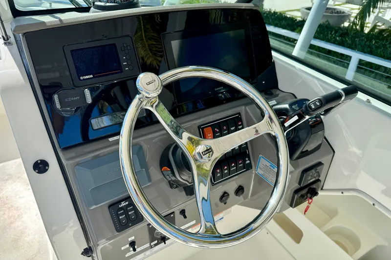 Slide: The Image of 2020 Pursuit DC 266 Dual Console boat dashboard with steering wheel and controls. - 7