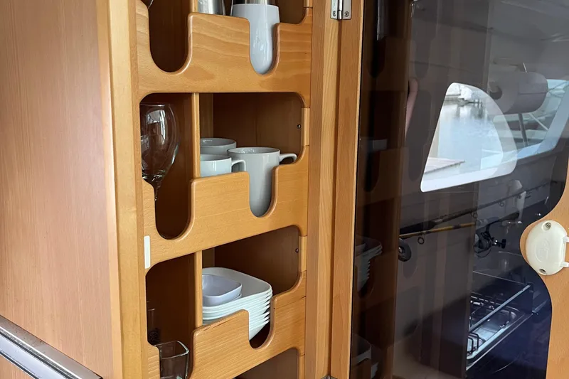 Slide: The Image of Wooden cabinet with dishes and cups in a 2008 Seawind 1160 yacht interior. - 10