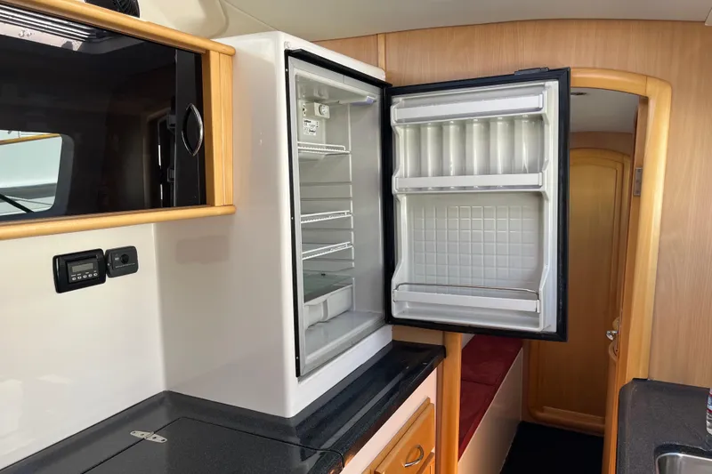 Slide: The Image of Interior of 2008 Seawind 1160 yacht featuring an open refrigerator in the galley. - 11