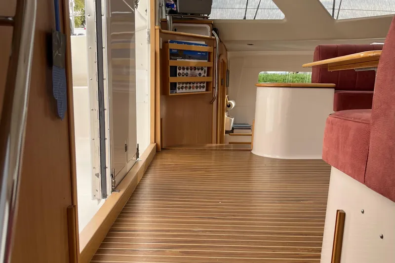 Slide: The Image of Interior of 2008 Seawind 1160 catamaran with wood flooring and red seating. - 12